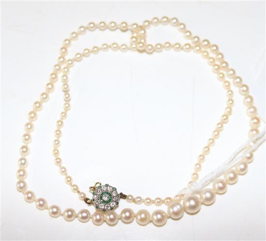 Early 20th century single strand graduated cultured pearl necklace with a diamond and garnet? cluster set circular clasp(-)